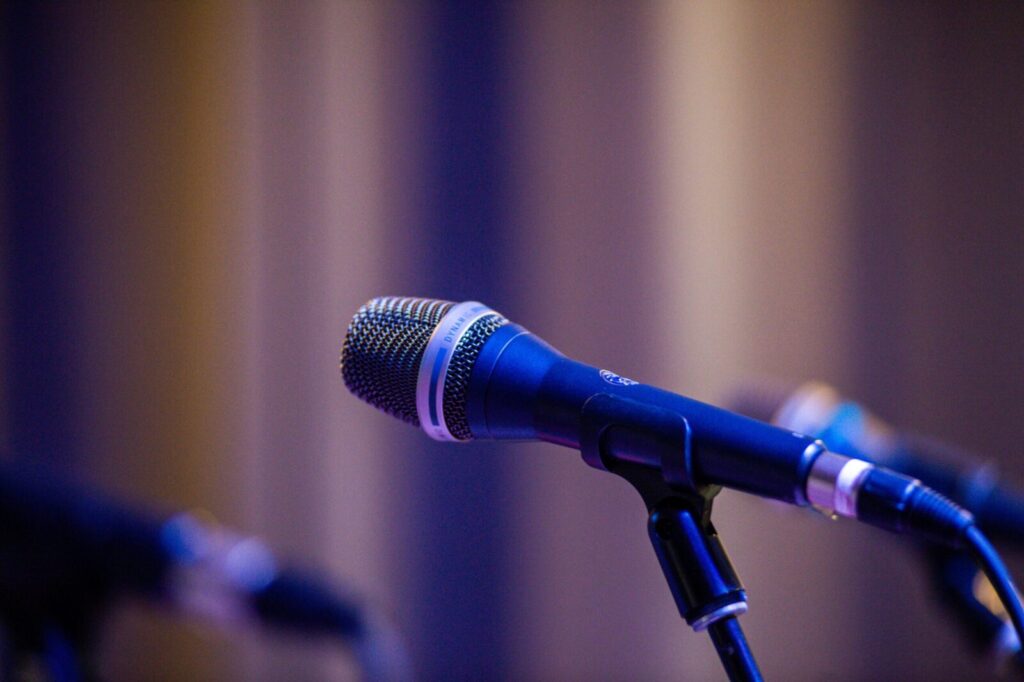 Close-up of a professional microphone on stage with blurred bokeh background.